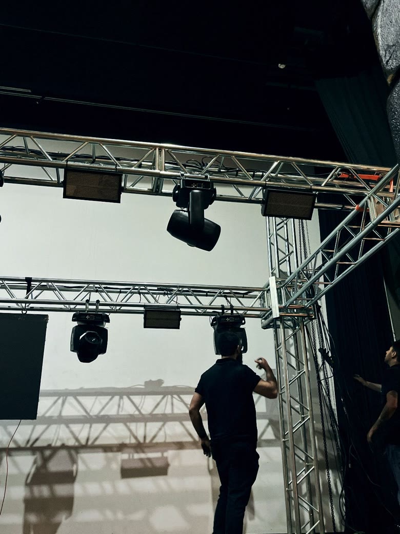 Equipe montando estrutura de treliça e iluminação nos bastidores antes do evento